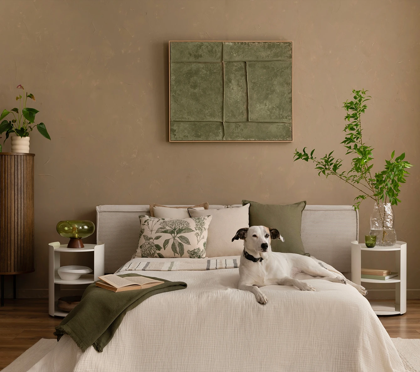 Sovrum med beige målad vägg, ljus säng och en hund på sängen